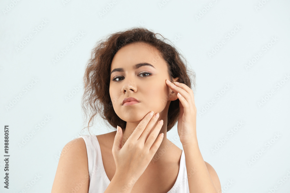 Beautiful young woman with acne problem on light background Beautiful young woman with acne problem on light background