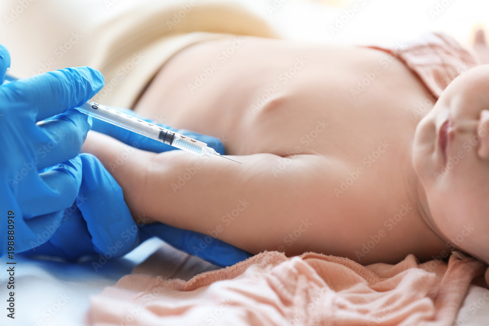 Doctor vaccinating baby in clinic, closeup