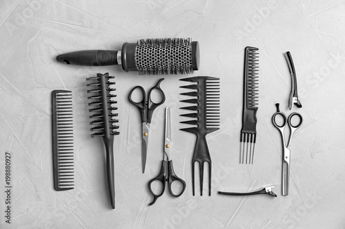 Flat lay composition with professional hairdresser tools on grey background