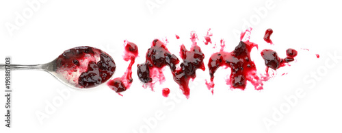 Spoon and sweet berry jam on white background