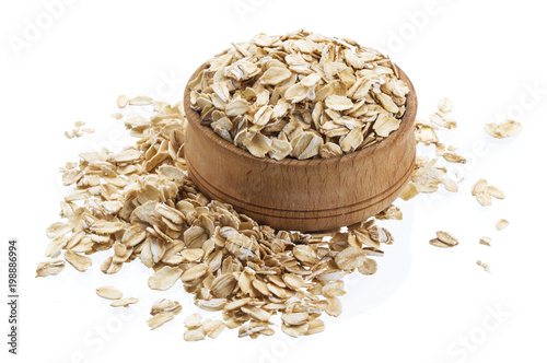 Oat flakes in wooden bowl isolated on white background