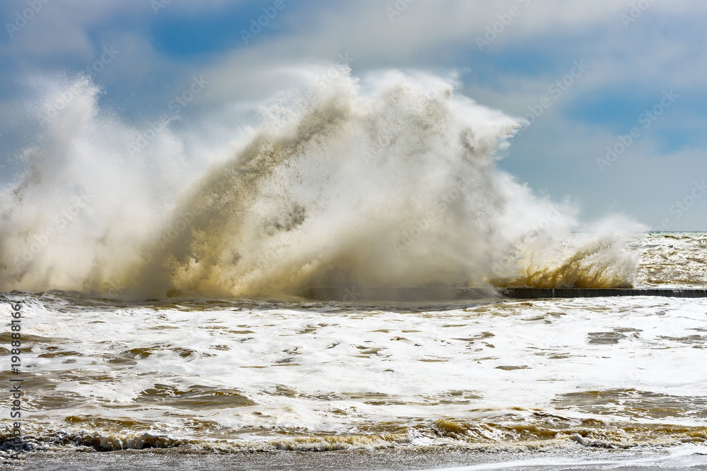Storm at Black sea coast in Odessa, Ukraine. Huge waves are crashing and spraying ashore during sunny day