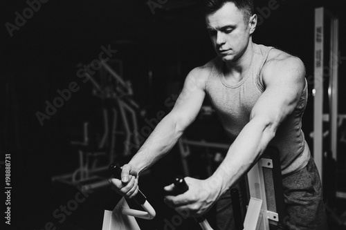 Strong handsome fit man exercising in the gym. Personal trainer workout. Athletic man working out his arms and chest muscles. Fitness, healhty lifestyle, bodybuilding concept.