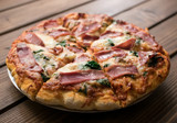 Homemade pizza with spinach, smoked ham. wooden background, copy space.