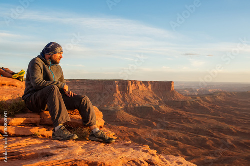 Hiker meets sunset at Grand view point in Canyonlands National park in Utah, USA © Maygutyak