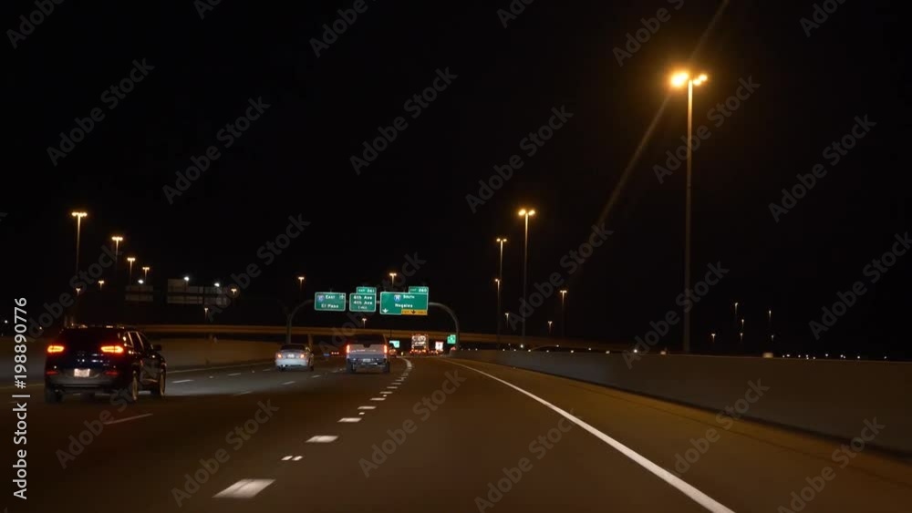 Night driving POV on a multi lane highway in a city