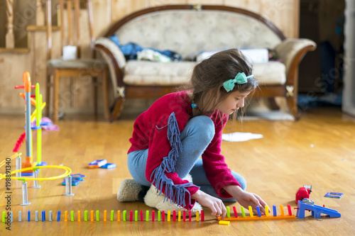 Girl 8 years old is played in the room with toys