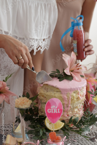 Group of women at a baby shower enjoying food and drink. Pregnant woman celebrating baby shower with female friends at home.