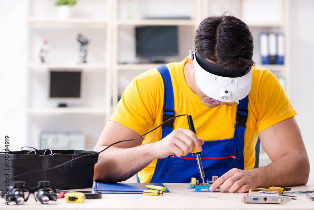Computer repair technician repairing hardware Computer repair technician repairing hardware