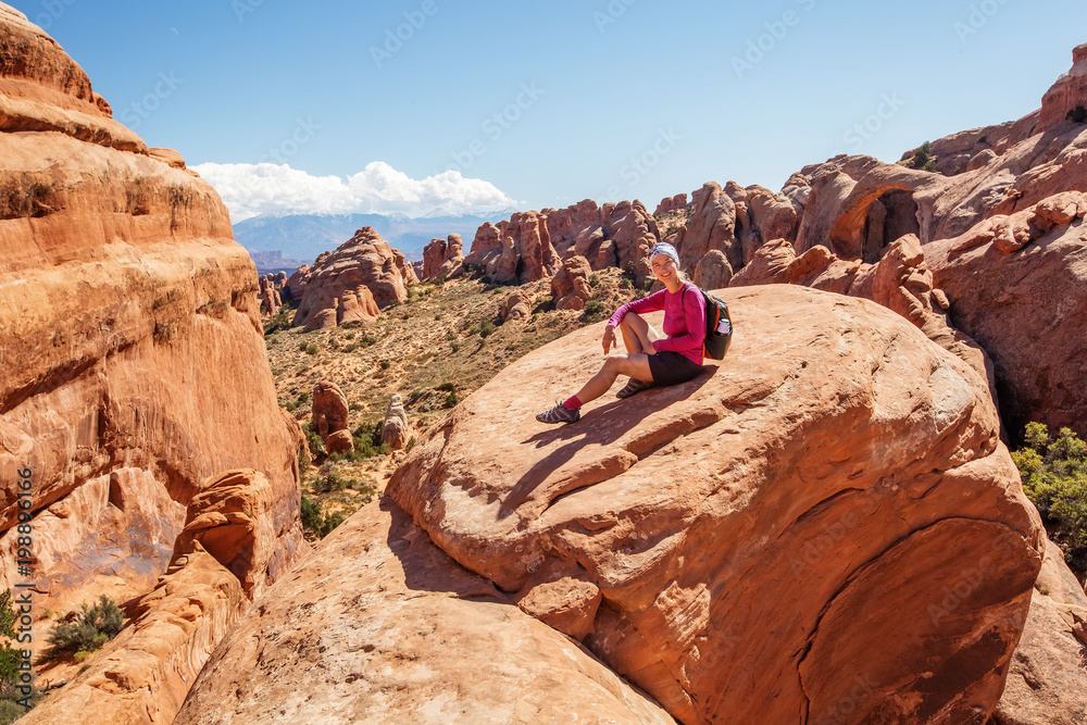 Hiker rests in Arches National park in Utah, USA Hiker rests in Arches National park in Utah, USA