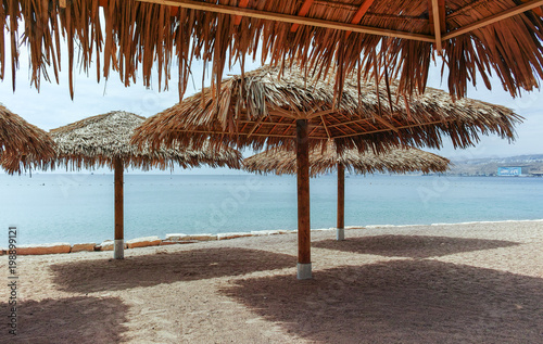 Fototapeta Naklejka Na Ścianę i Meble -  Beautiful public sandy beaches on Red Sea in Eilat with stro umbrellas, luxury vacation spa resorts in Israel