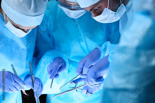 Group of surgeons at work while operating at hospital. Health care and veterinary concept
