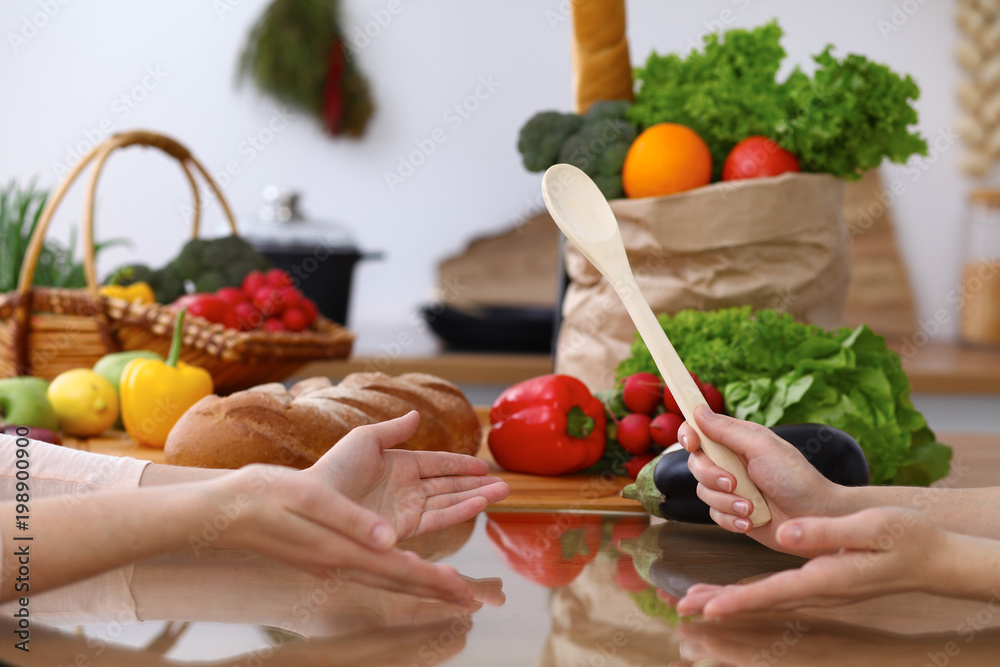 Closeup of human hands cooking in kitchen. Women discuss a menu. Healthy meal, vegetarian food and lifestyle concepts