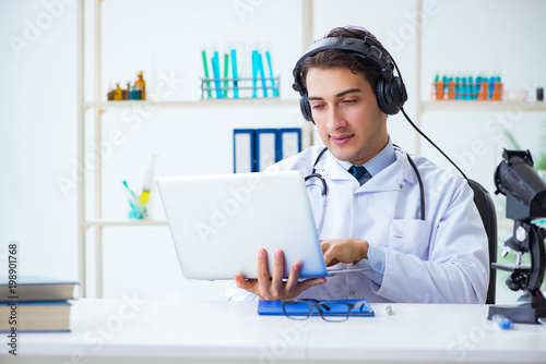 Male doctor listening to patient during telemedicine session © Elnur