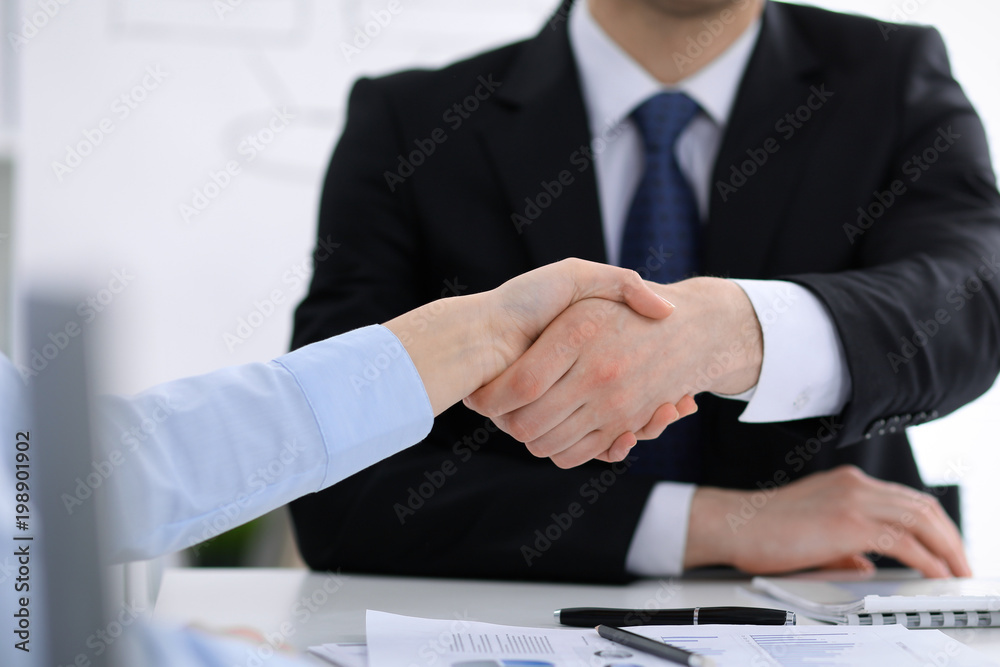 Close Up of unknown business people shaking hands while finishing up a meeting. Handshaking, agreement or success concept in people communication Close Up of unknown business people shaking hands while finishing up a meeting. Handshaking, agreement or success concept in people communication