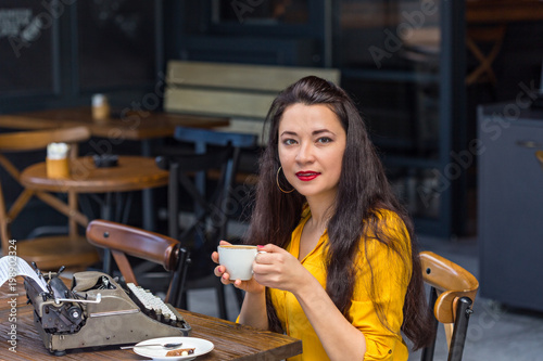 Writer female working in a coffee shop using a retro typewriter