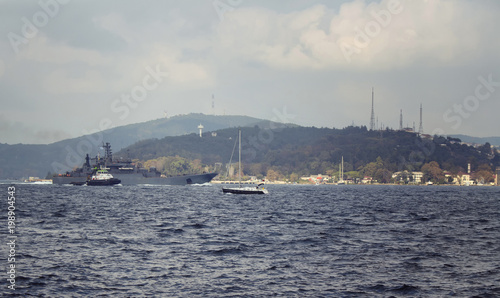 Motorboat and war ship cross Bosphorus strait in Tarabya area of Istanbul. © theendup