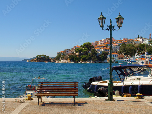 Wooden bench and street lamp on the promenade in Skiathos, Greece