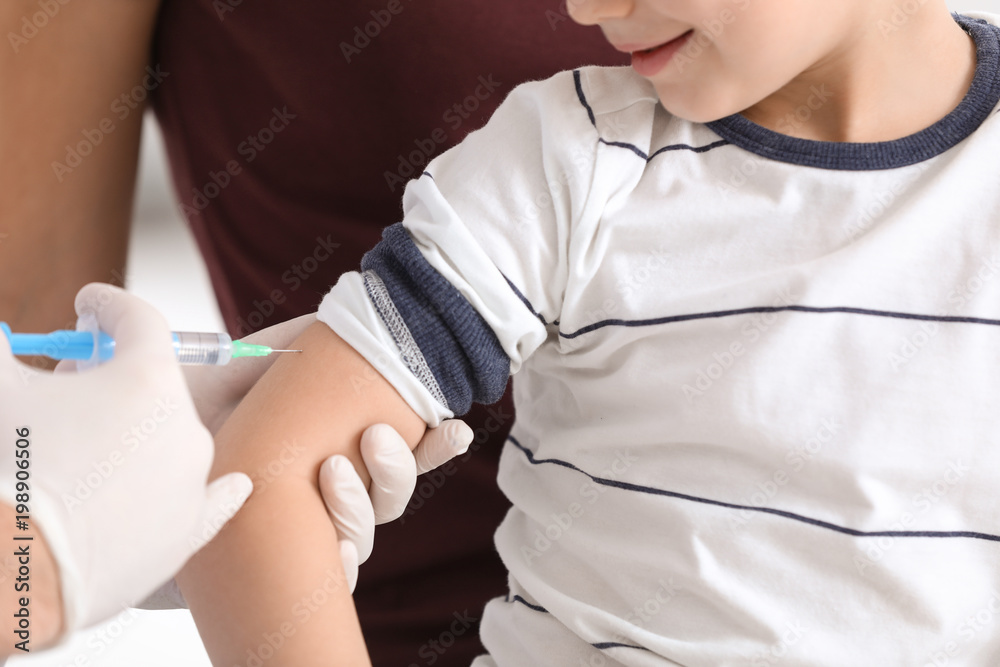 Children's doctor vaccinating little boy in hospital