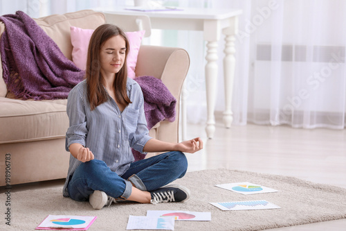 Young woman meditating on floor at home