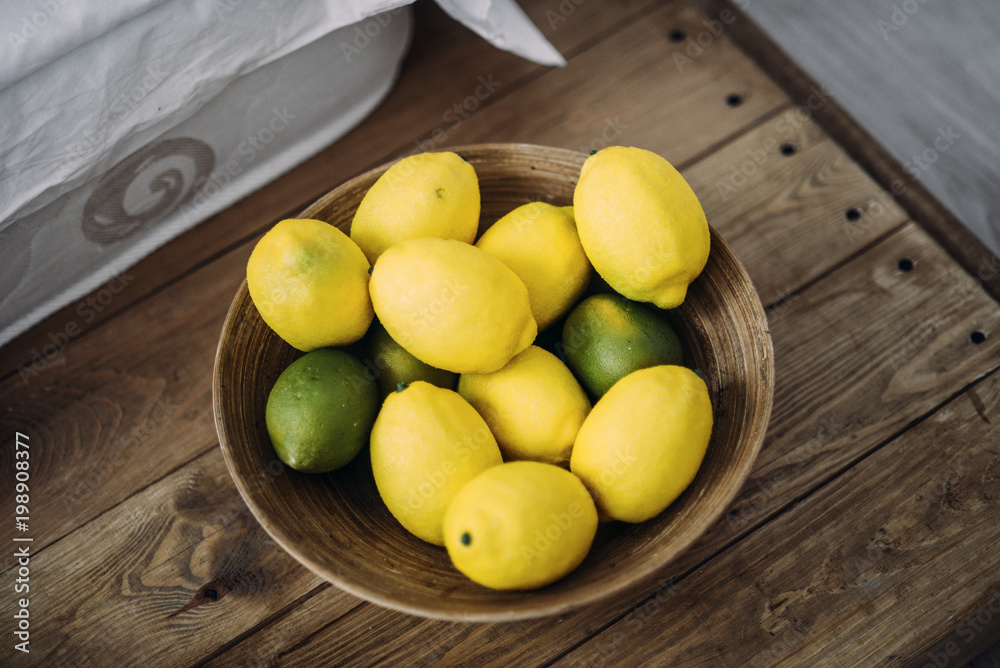 a dish of lemons and limes on the wooden table 2 a dish of lemons and limes on the wooden table 2