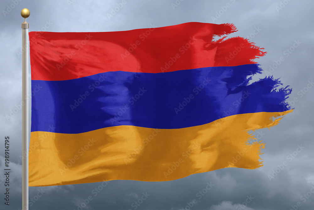 Obraz premium Armenia Flag with torn edges in front of a stormy sky