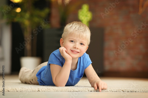 Cute little boy lying on fl...