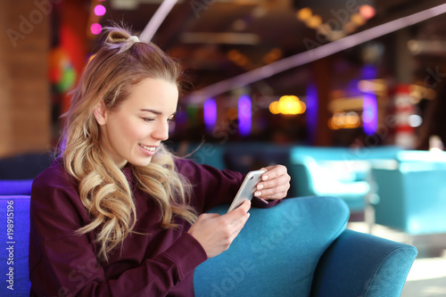 Young woman with mobile phone indoors