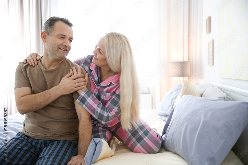 Senior couple on bed together at home