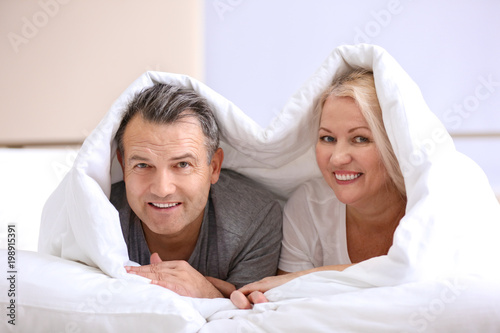 Senior couple under blanket...
