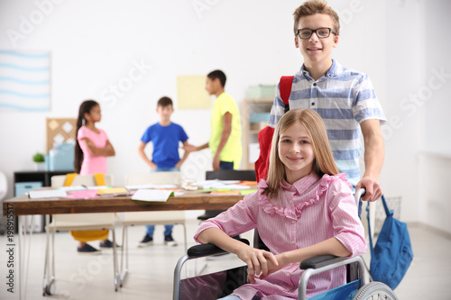 Boy helping girl in wheelch...
