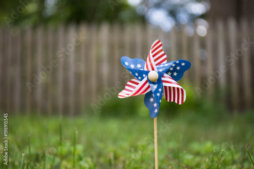 A close up bokeh photo of a pinwheel with the american flag stars and strips pattern.