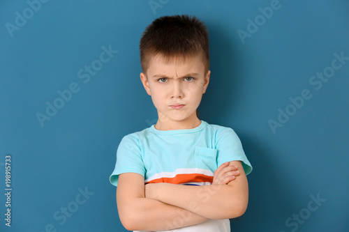 Portrait of emotional little boy on color background