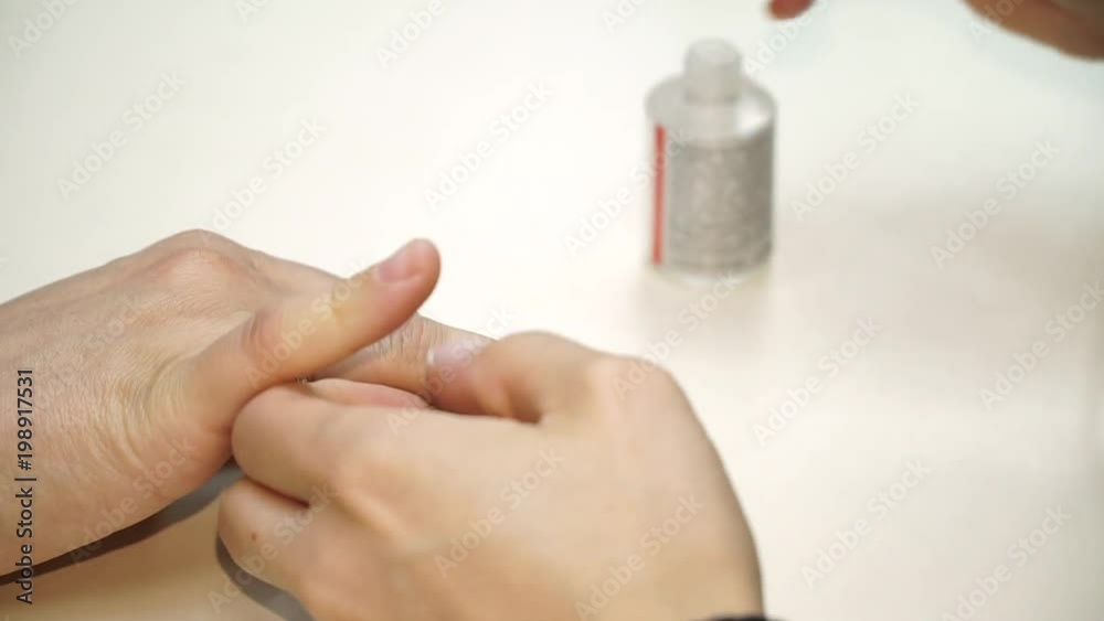 Pretty woman on the procedure of paints the nails. Decoration polish on the nail Pretty woman on the procedure of paints the nails. Decoration polish on the nail