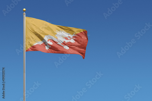 Bhutan flag in front of a clear blue sky