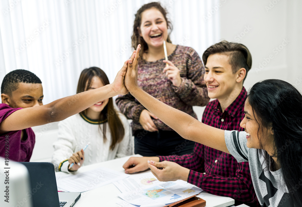 Fototapeta premium Classmates giving a high five teamwork and success concept