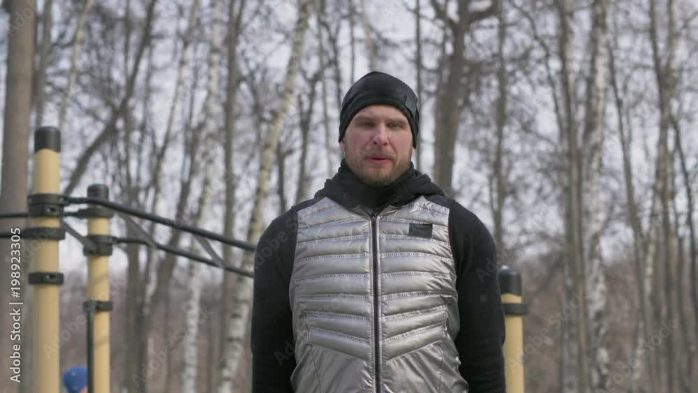 Portrait fitness man doing push ups exercise on bar on winter sport ground Portrait fitness man doing push ups exercise on bar on winter sport ground