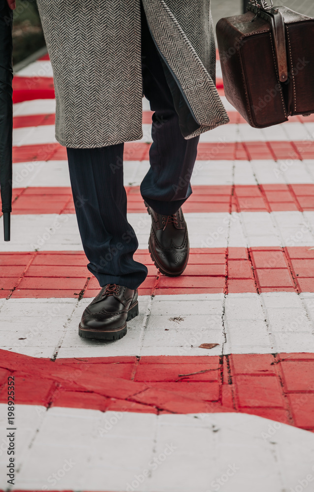 man with bag and in coat walks along street man with bag and in coat walks along street