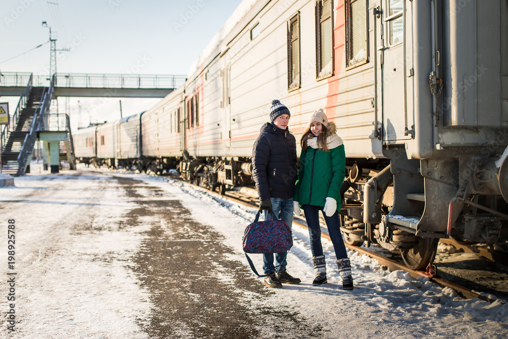 Couple at railway station near train in a winter time