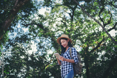 young woman traveler using the phone in the forest