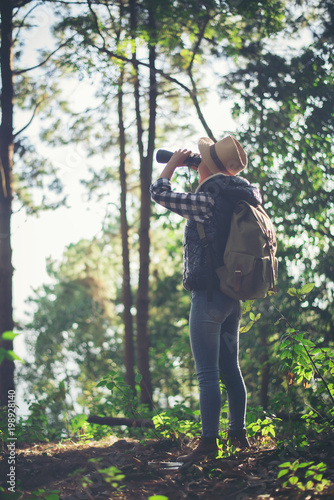 Woman with Binoculars walking in the forest