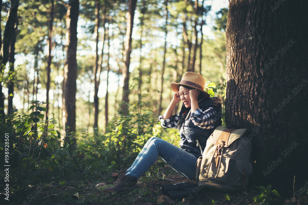 Happy woman seated on the ground in the forest Happy woman seated on the ground in the forest