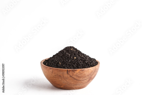 Nigella sativa or Black cumin in wooden bowl on white background, copy space, isolate