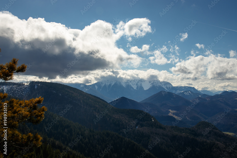 clouds covering the peak of a high mountain