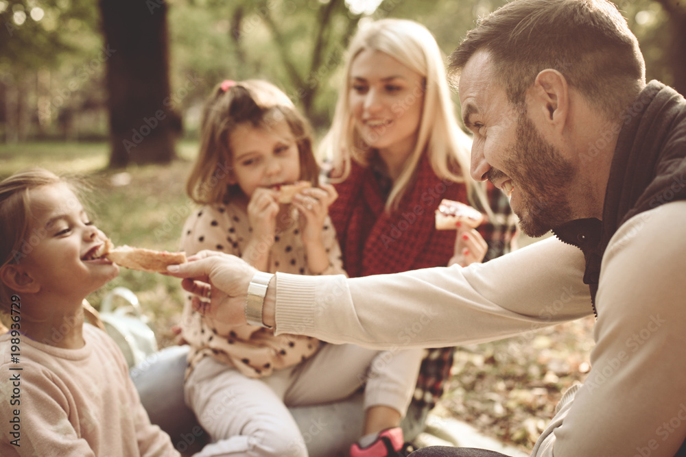 Family having picnic in park.