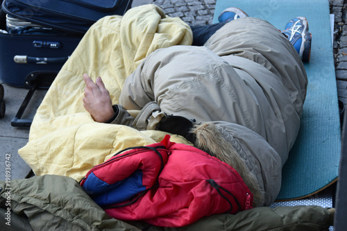 Obdachloser mit Schlafsack und Iso-Matte