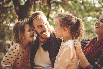 Happy family in park having conversation and hugging.