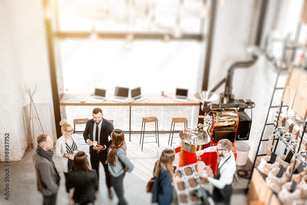 © rh2010 - Business people talking and having fun durnig a coffee time in the modern cafe interior. Wide view from above tilt shift effect