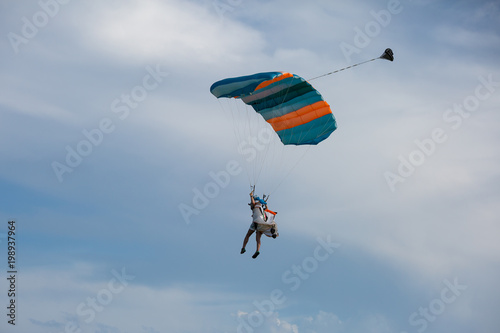 Parachutist with Blue Parachute against Clear Blue Sky