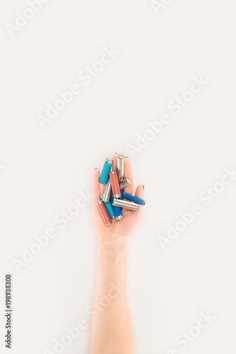 cropped shot of woman holding batteries isolated on white